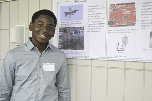 High School student, Darius Jackson, standing by his research poster at the conclusion of the Young Scholar program.